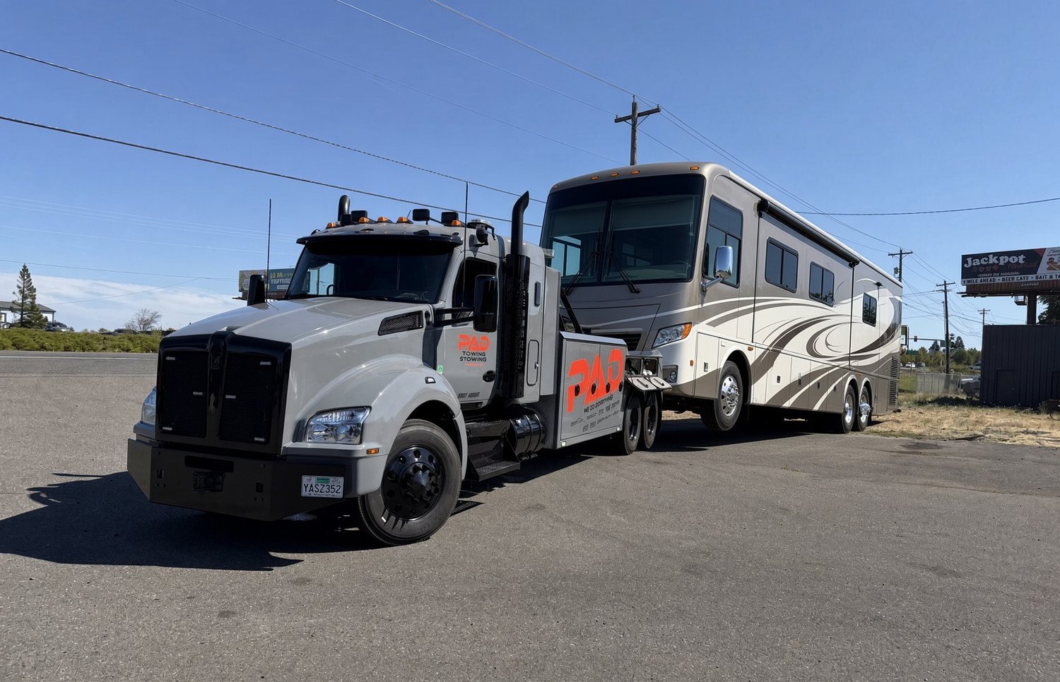 PAD heavy-duty wrecker towing a Class A motorhome on the highway